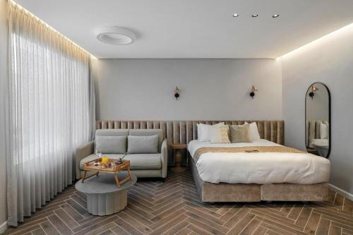 a hotel room with a bed and a chair at ריזורט האחוזה -מתחם וילה וסוויטות עם בריכה משותפת מול נוף ים המלח in Neve Zohar