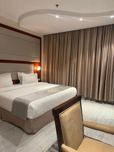 a hotel room with a large bed and a chair at شركة منازل التوت للشقق المخدومة جده in Jeddah