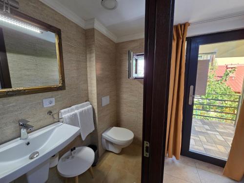 a bathroom with a sink and a toilet and a mirror at Poet Palace Bucharest in Bucharest