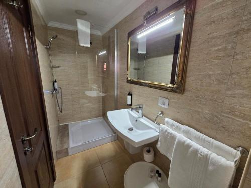 a bathroom with a sink and a toilet and a mirror at Poet Palace Bucharest in Bucharest