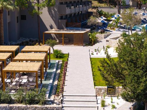an outdoor patio with tables and benches at Cabú Hotel - Adults Only in Faliraki