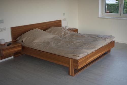 a bed in a room with a wooden frame at Weitblick im Taunus in Kelkheim