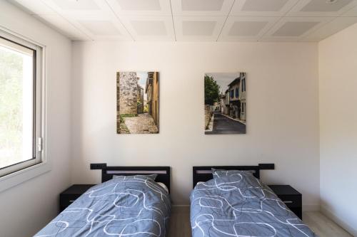 - 2 lits dans une chambre avec 3 photos sur le mur dans l'établissement La maison Carla, à Fumel