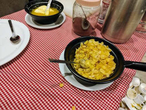 a table with a bowl of food on a table at Hotel Candor Amigo Airoli Mind Space in Navi Mumbai