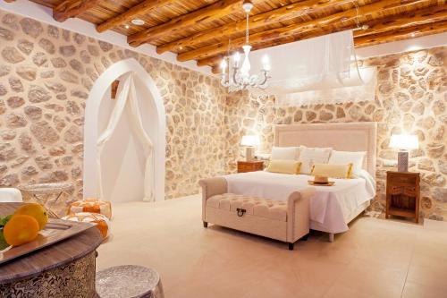 a bedroom with a white bed and a couch at Villa Morna Valley in Sant Joan de Labritja