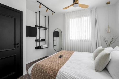 a bedroom with a bed and a ceiling fan at ריזורט האחוזה -מתחם וילה וסוויטות עם בריכה משותפת מול נוף ים המלח in Neve Zohar