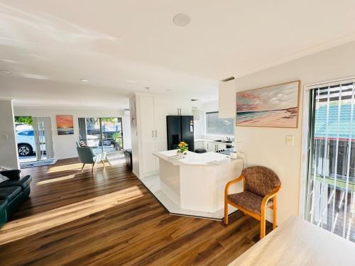 a kitchen and living room with a counter and a chair at Deluxe Beauty House near Auckland Airport and City in Auckland