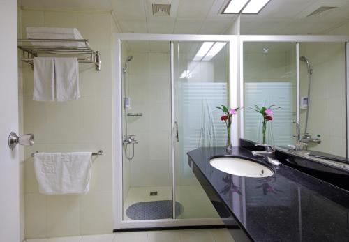 a bathroom with a sink and a glass shower at LN Whitehouse Hotel in Guangzhou