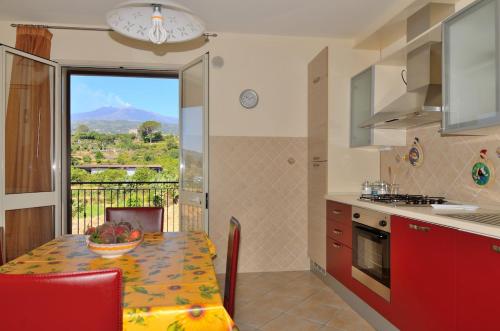 a kitchen with a table with a bowl of fruit on it at Between Etna and Tormina in Piedimonte Etneo