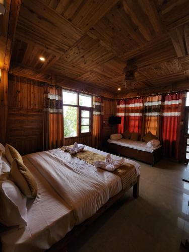 a bedroom with a large bed in a wooden room at Sneh by Daisey in Cheog