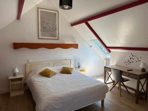 a bedroom with a bed and a desk and a window at Logis Hôtel La Demeure du Perron in Quettehou