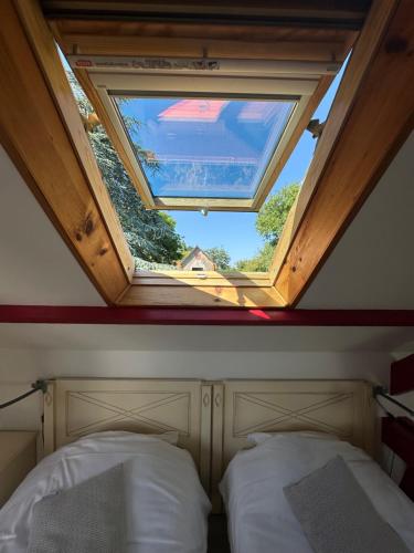 a bedroom with a skylight and two beds in it at Logis Hôtel La Demeure du Perron in Quettehou