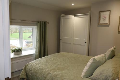 a bedroom with a bed and a window at Brocken Brae Cottage in Easby