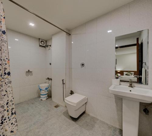 a bathroom with a toilet and a sink and a mirror at Hotel Vishram in Bijāpur