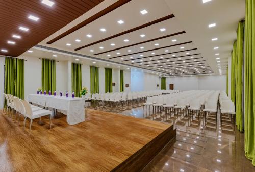 a large banquet hall with white tables and chairs at Hotel Vishram in Bijāpur