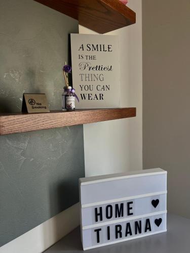 a smile is the prettiest thing you can wear sign on a shelf at Shehu Apartments in Tirana
