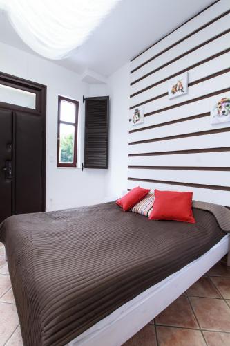 a bedroom with a large bed with red pillows at Ecoappartment in Mosonmagyaróvár