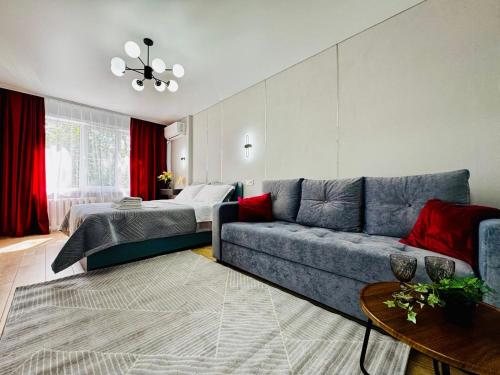 a living room with a couch and a bed at Квартира - Кэнди in Ustʼ-Kamenogorsk