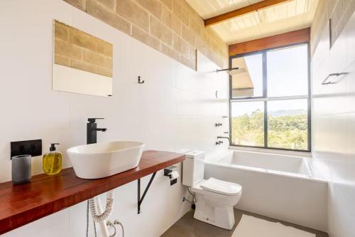 une salle de bain avec un lavabo et des toilettes et une fenêtre dans l'établissement Refugio Cunha - Vista Panorâmica, à Cunha