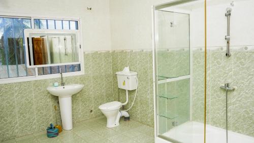 Un baño con inodoro, lavabo y ducha. en MB Properties - Sinchu Alagie, en Madina Sey Kunda