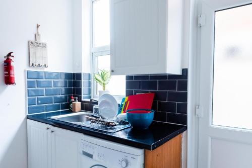 a kitchen with a sink and a washing machine at Valla Retreat Serviced Stay in Northampton Town Centre in Northampton