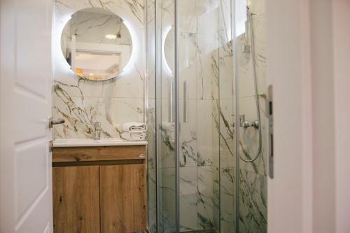 a bathroom with a shower with a sink and a mirror at Premium apartments in Ulcinj