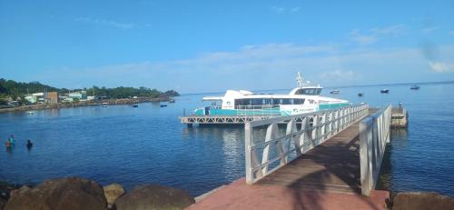 a boat is docked at a dock on the water at Gîtes Capra Pomme Surette piscine et spa in Bouillante