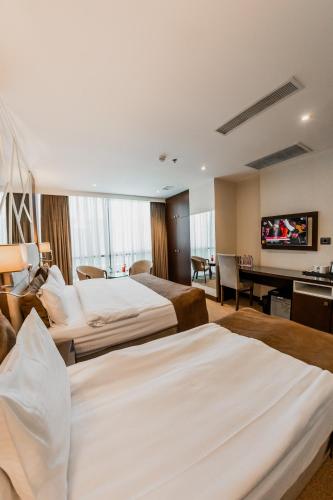 a hotel room with two beds and a flat screen tv at Hotel Diamond in Baku