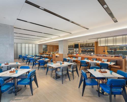 a dining room with tables and blue chairs at Fairfield by Marriott Yining in Yining