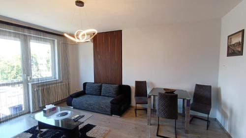 a living room with a chair and a table at Nidius Apartment in Debrecen
