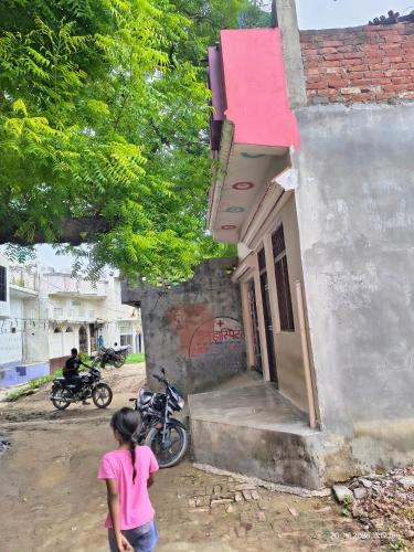a woman standing outside of a small building at Sundara Home Stay in Lucknow