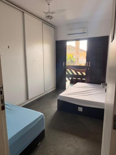 a bedroom with two beds and sliding glass doors at Casa na praia de Bertioga com Pscina e Churrasqueira - até 10 Pessoas in Bertioga