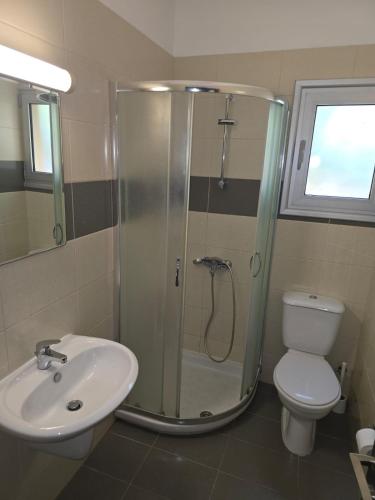 a bathroom with a shower and a toilet and a sink at Regina by the Sea in Limassol