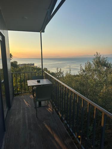 a balcony with a table on a deck with a view at Lake Escape Villa Shirokë in Shkodër