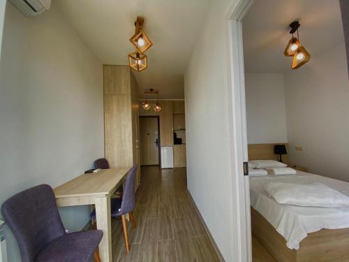 a bedroom with a bed and a table and chairs at Green House - Apartment with Separate Room and Sea View in Batumi