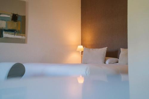 a hotel room with a bed with white pillows at Hotel Aigue Marine in Tréguier