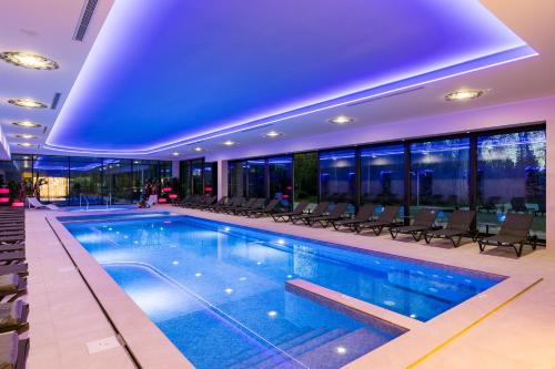 a large swimming pool in a building with chairs at Mayak Resort in Kyiv