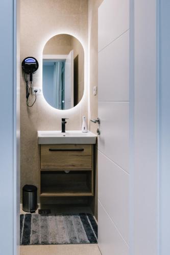 a bathroom with a sink and a mirror at Apartments Valentina free parking in Mostar