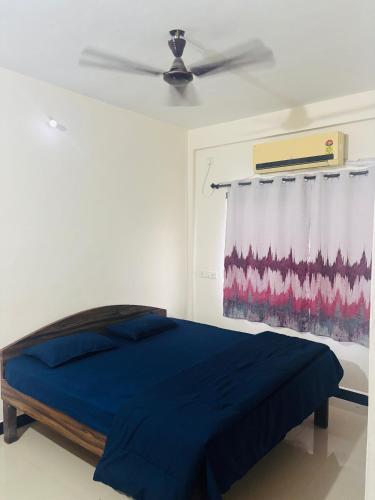 a bedroom with a blue bed and a ceiling fan at Aashray Guestroom in Murud