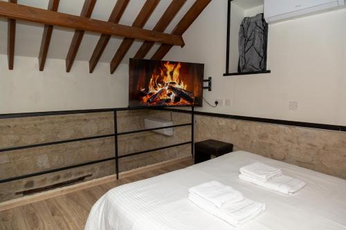 a bedroom with a bed and a fireplace at Sente Loft Suite in Paphos City