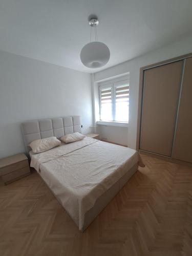 a bedroom with a large bed in a white room at Angela Modern Apartment in Bitola