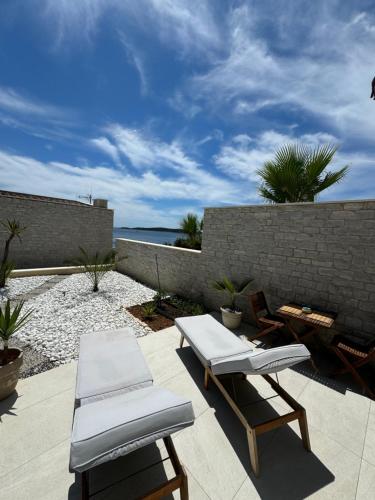 un patio con 2 tumbonas y el océano en Sudio by the Sea, en Milna