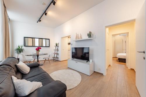 a living room with a couch and a television at Cosy flat in Brussel Center in Mellet