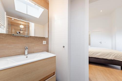a bathroom with a sink and a bed in a room at Cosy flat in Brussel Center in Mellet