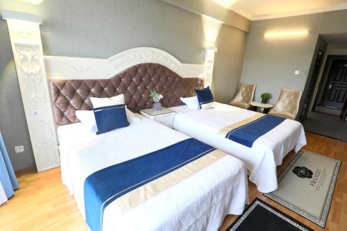 a hotel room with two beds and a large headboard at Guilin Green Bamboo Hotel in Guilin