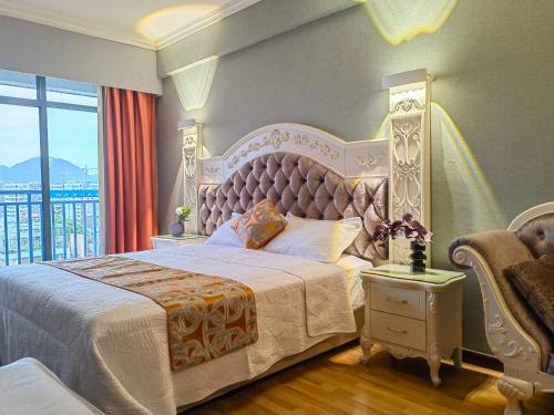 a bedroom with a large white bed and a window at Guilin Green Bamboo Hotel in Guilin