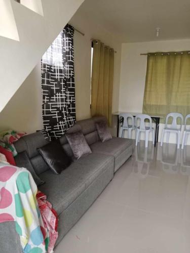 a living room with a couch and a table and chairs at Casa mira coast in Dumaguete Airport