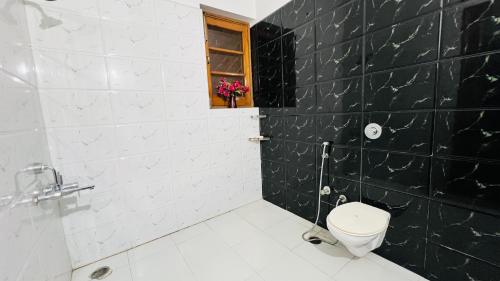a bathroom with a toilet and a window at The Lawn House : 3BHK Furnished Villa with Lawn in Amritsar