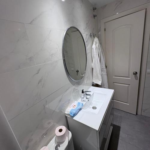 a white bathroom with a sink and a mirror at Marbella urbanización privada in Marbella