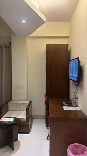 a room with a bed and a desk and a television at Hotel The Grand Hyatt Dhaka in Dhaka